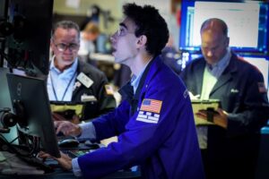 Dow touches record high as oil slides further