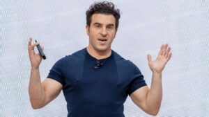 Humans need to ‘surf the wave’ of AI rather than get swallowed by it, Chesky says at Communacopia